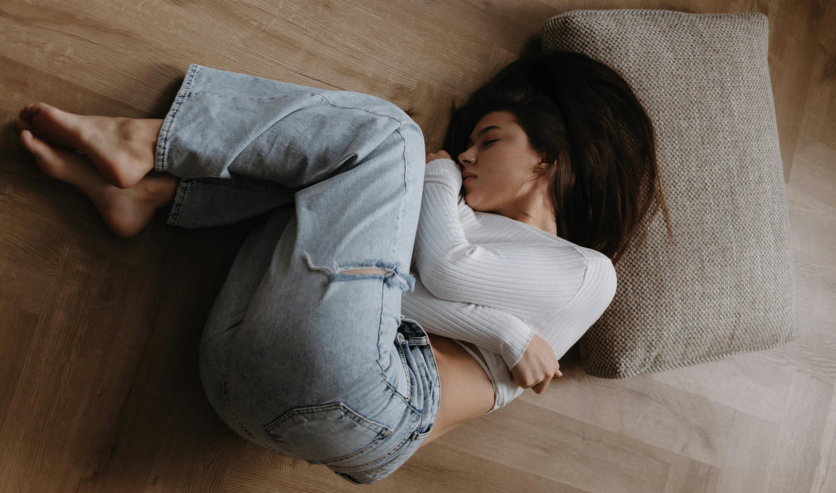 woman curled up on the floor in jeans